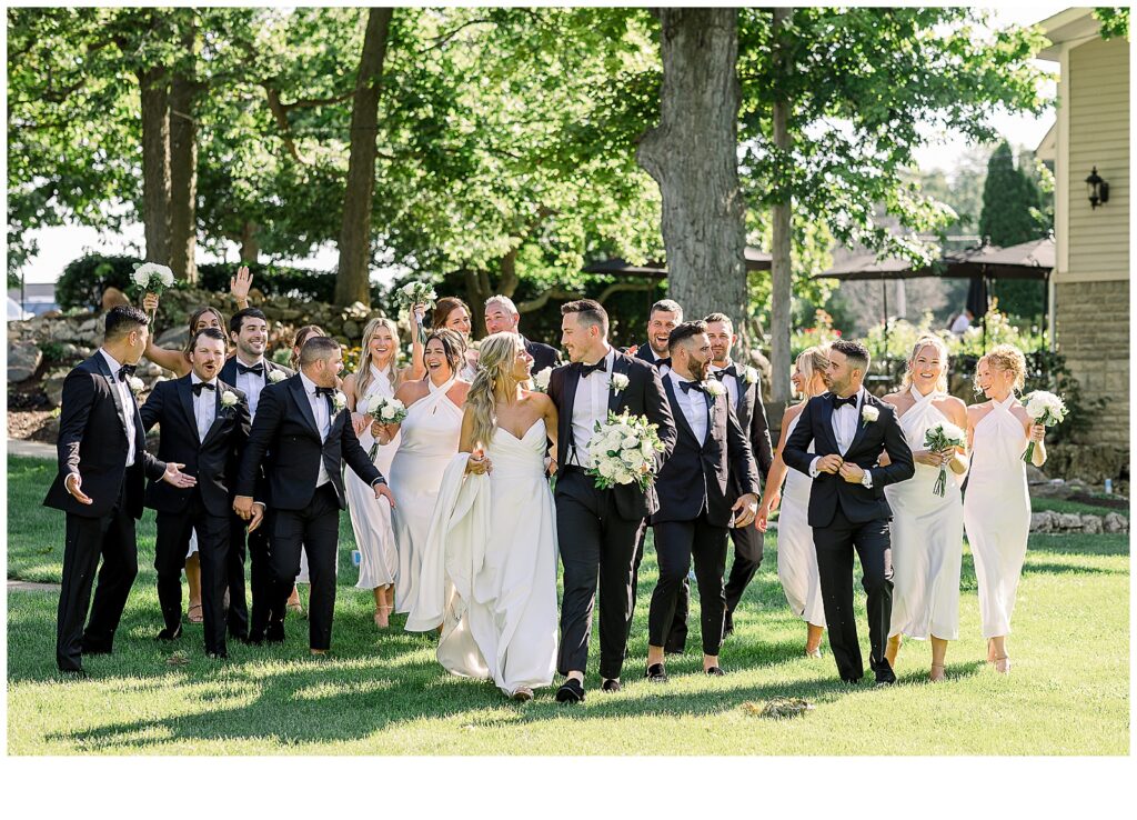 A wedding party walk joyfully on the grounds of Gideon Owen Wine Company in Catawba Island, Ohio.